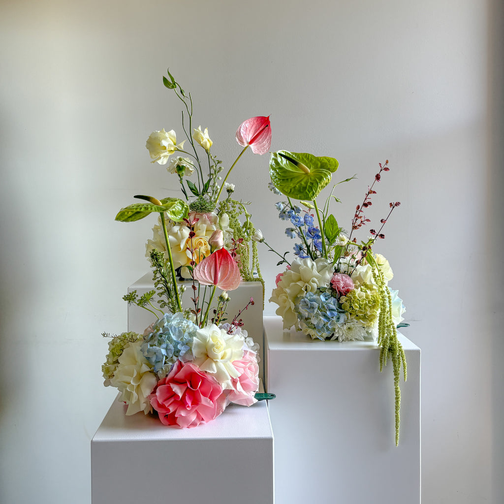 three floral clouds on white acrylic plinths